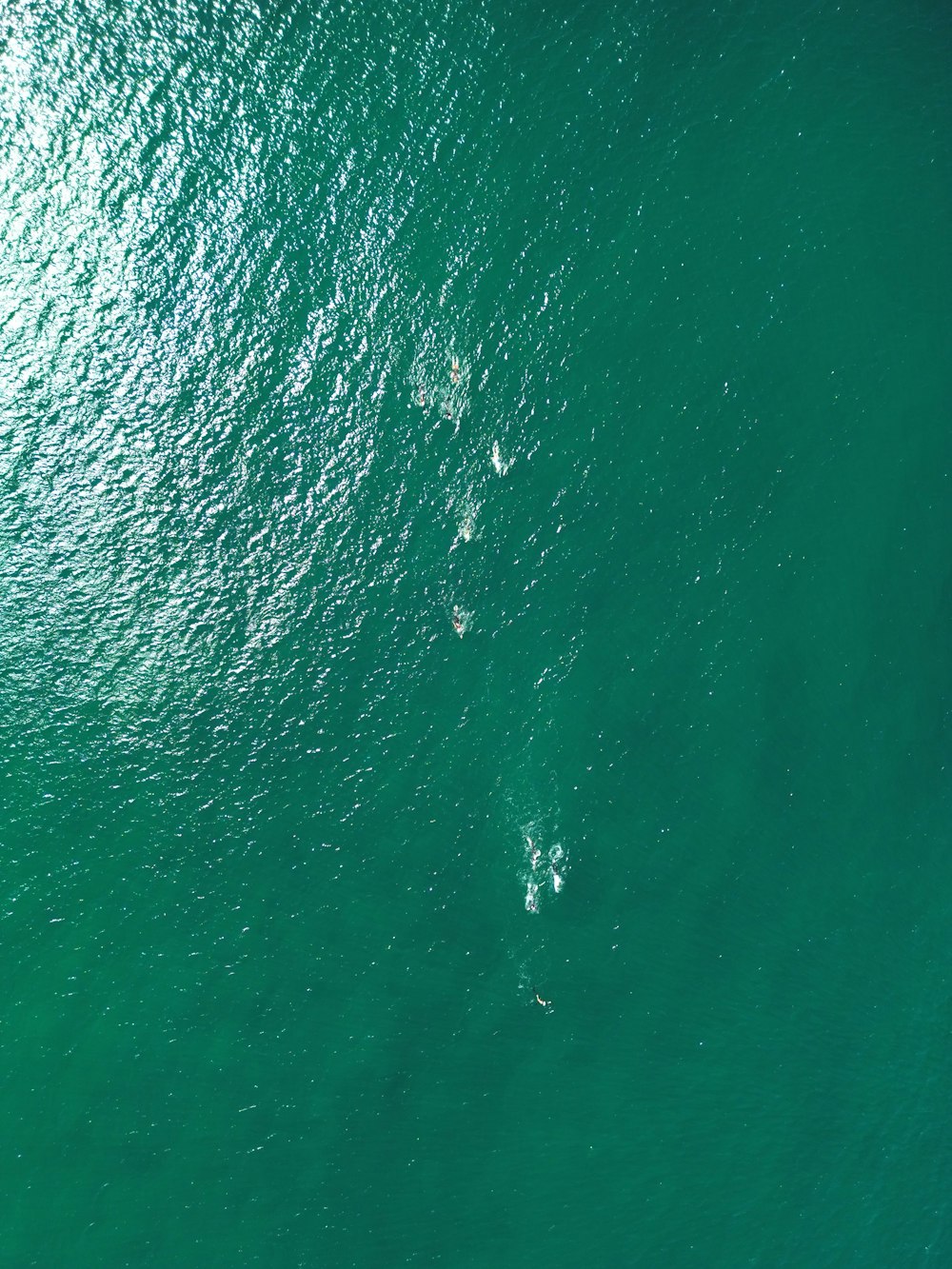 a couple of people riding on top of a surfboard in the ocean