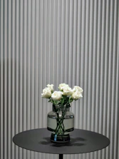 A minimalist black and gold vase arrangement on a white marble table.