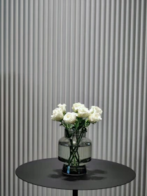 A minimalist black and gold vase arrangement on a white marble table.