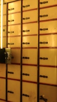 Rows of safe deposit boxes inside a secure bank vault area.
