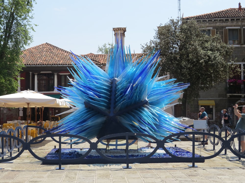 a blue sculpture sitting on top of a metal bench