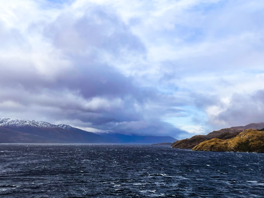 a large body of water with mountains in the background