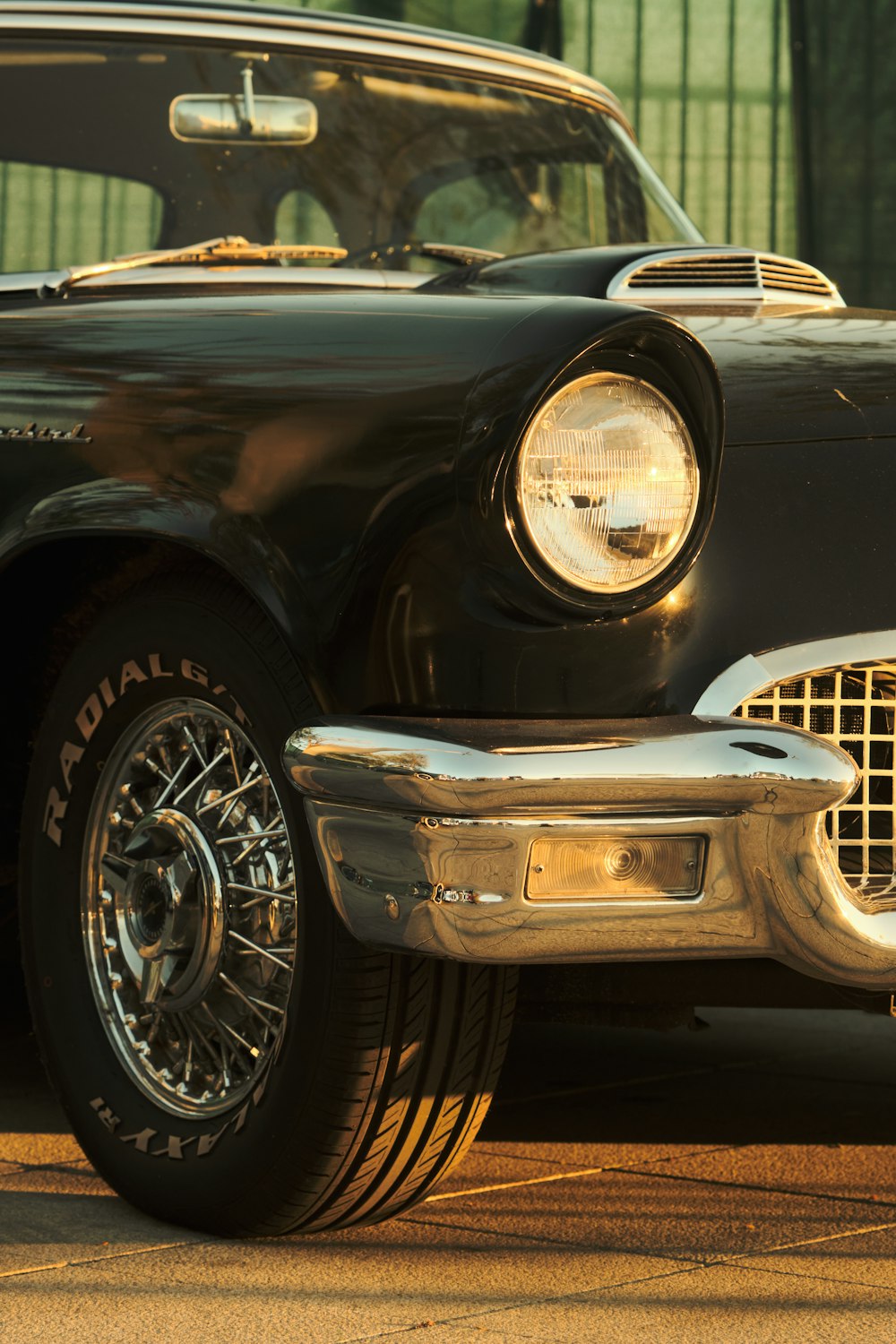 an old black car parked in front of a building