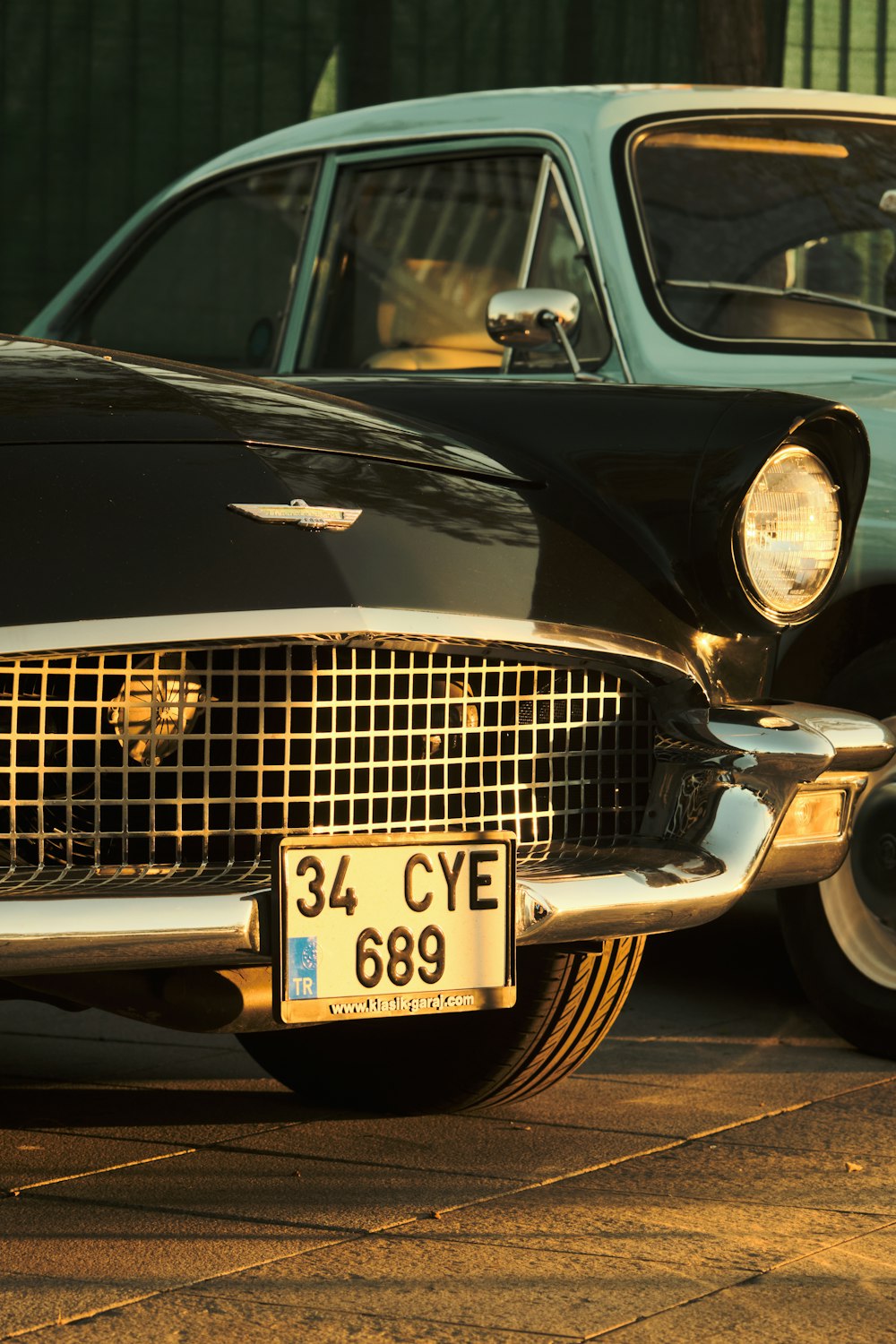 a classic car is parked next to another car