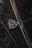 A close-up of a luxury car emblem adorned with raindrops, showcasing sleek chrome details against a dark, glossy surface.