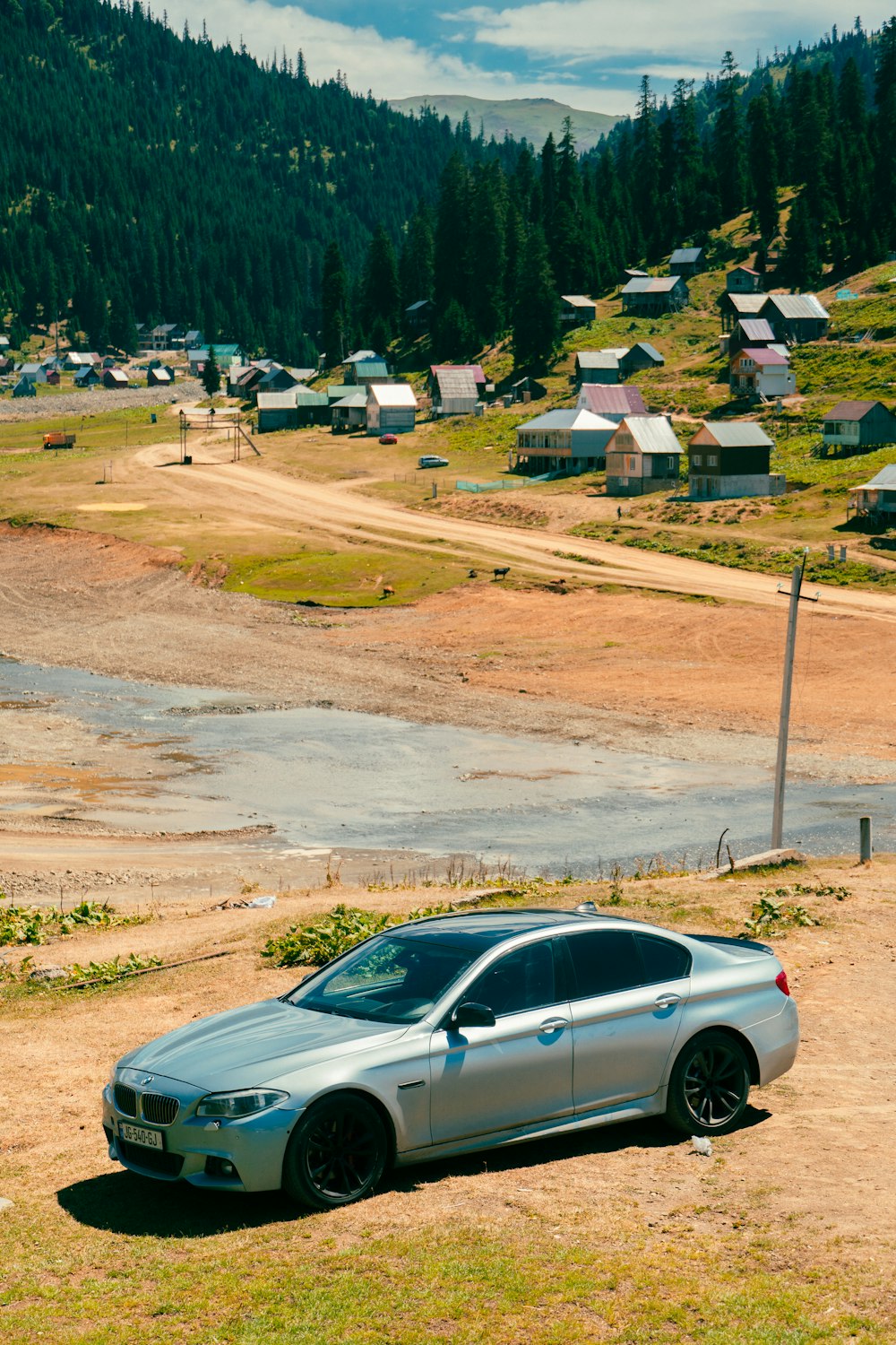 a silver car parked on a dirt road