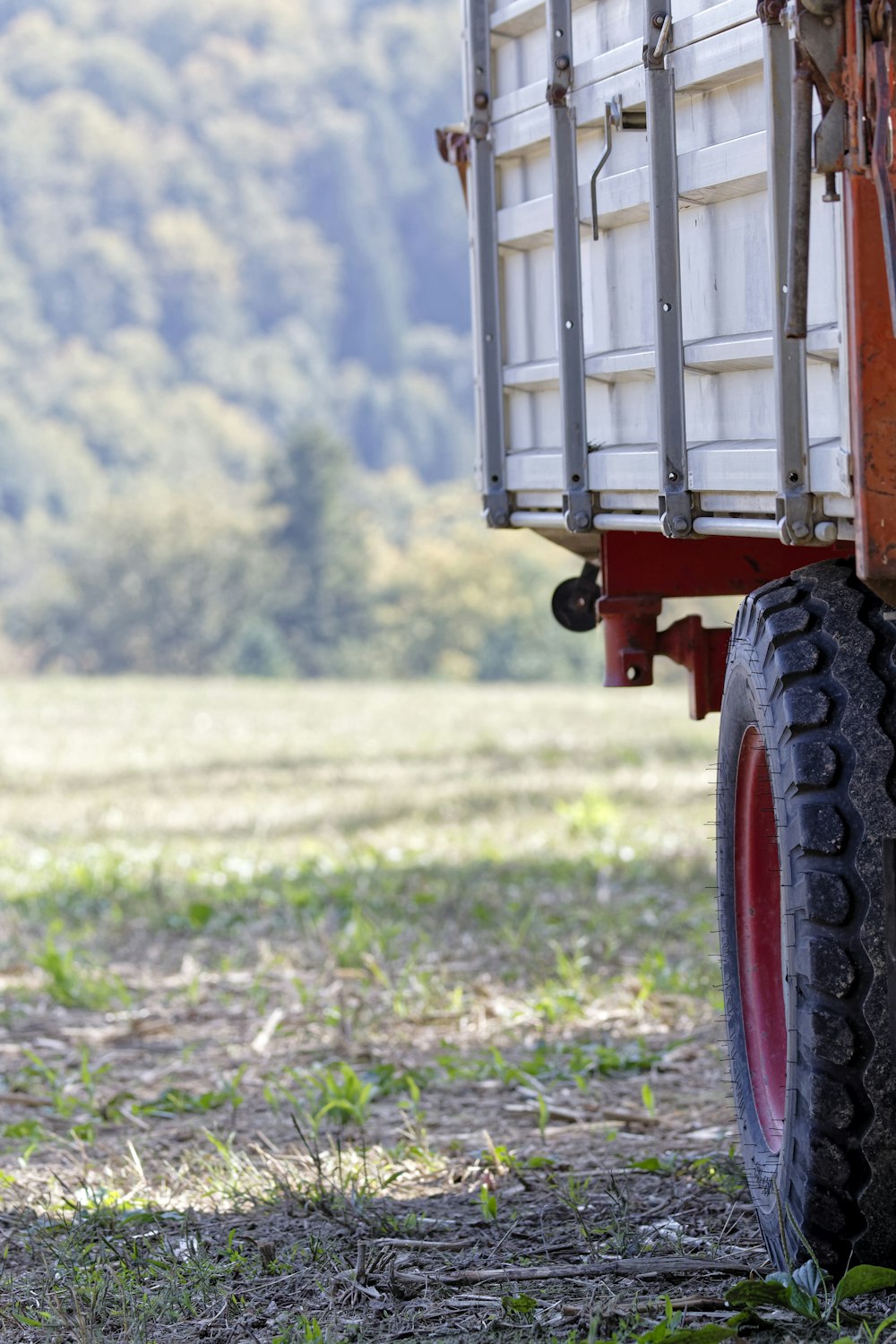 a red and white truck parked on top of a grass covered field