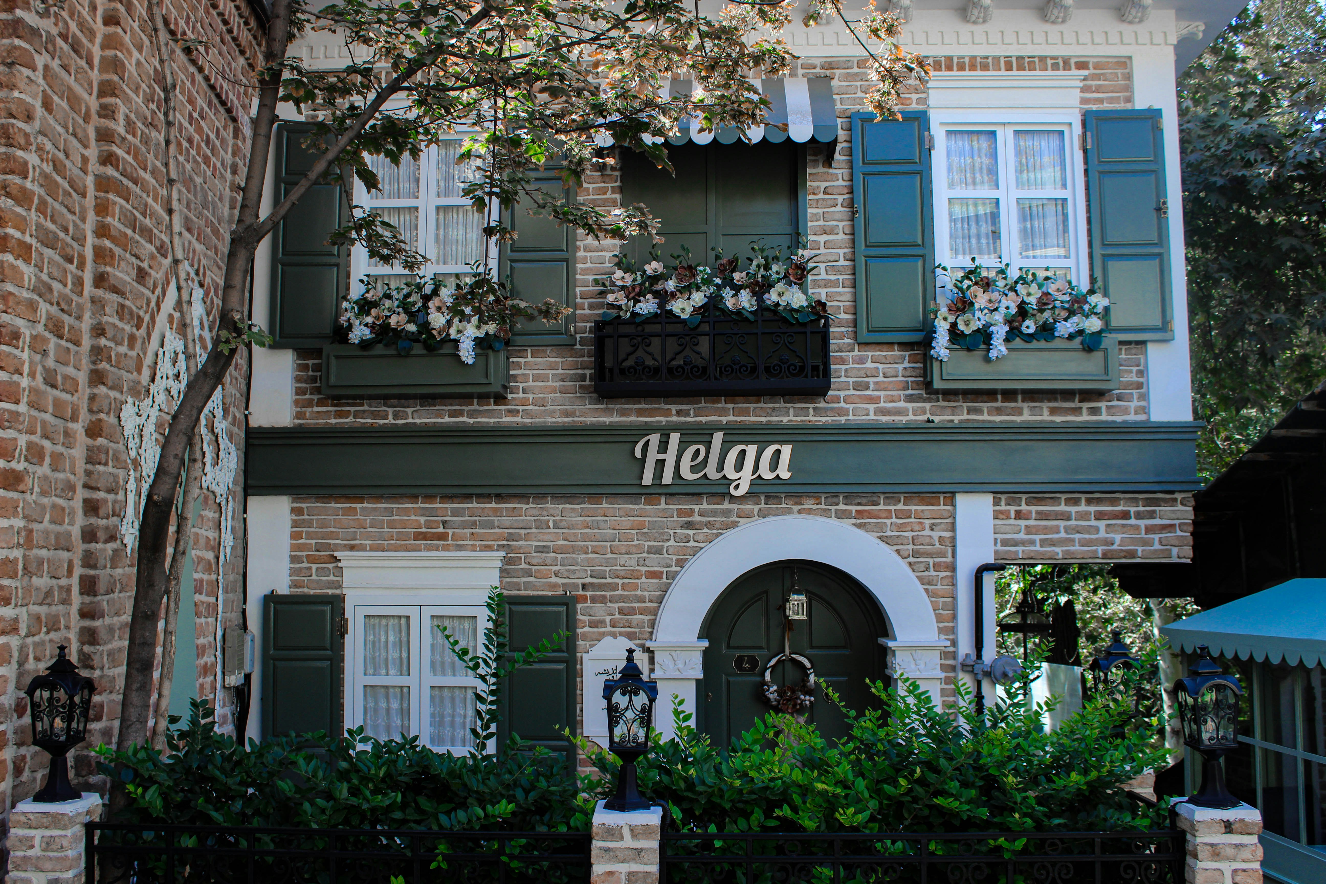 a brick building with green shutters and windows