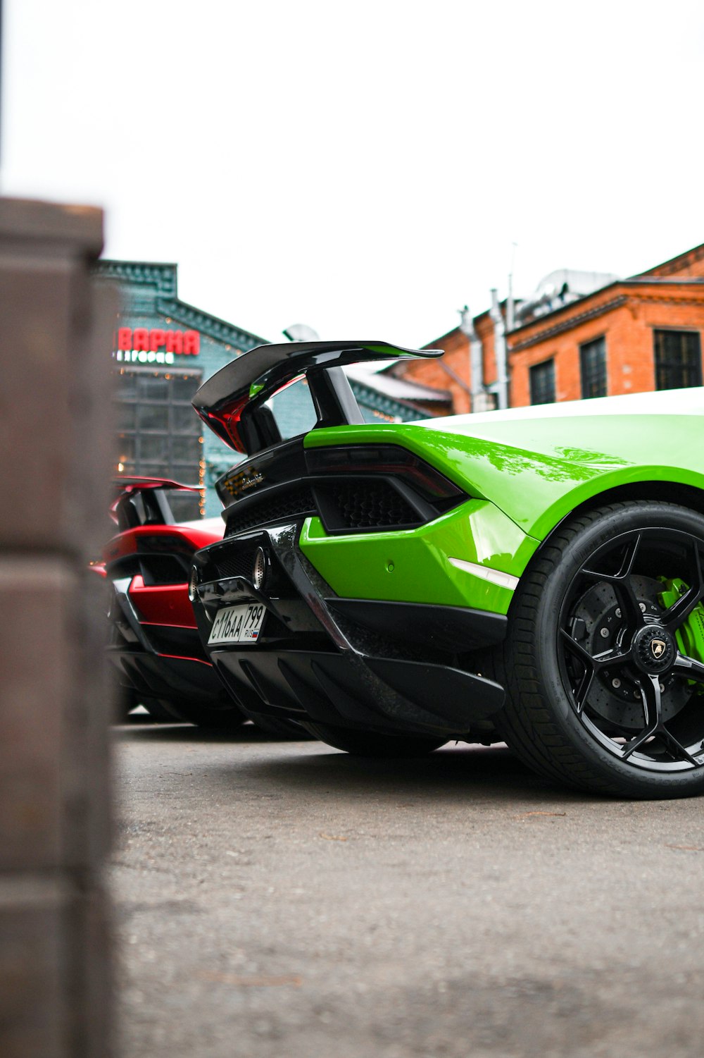 a green and black sports car parked in a parking lot