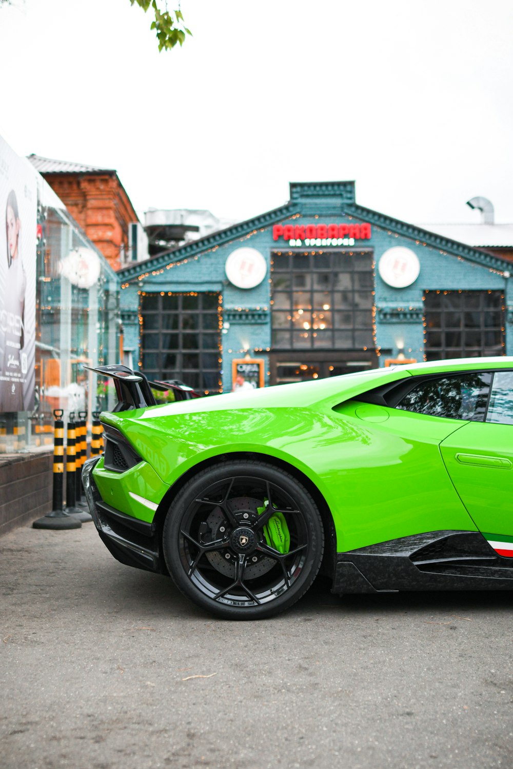 a green sports car parked in front of a building