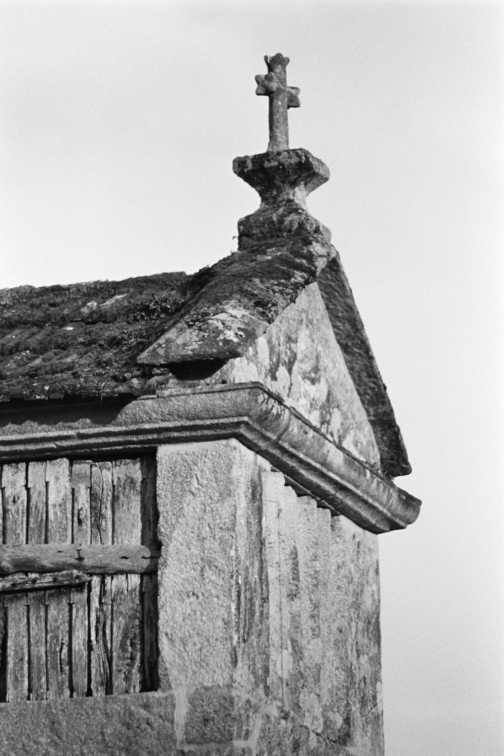 Ein Schwarz-Weiß-Foto eines Gebäudes mit einem Kreuz auf der Spitze