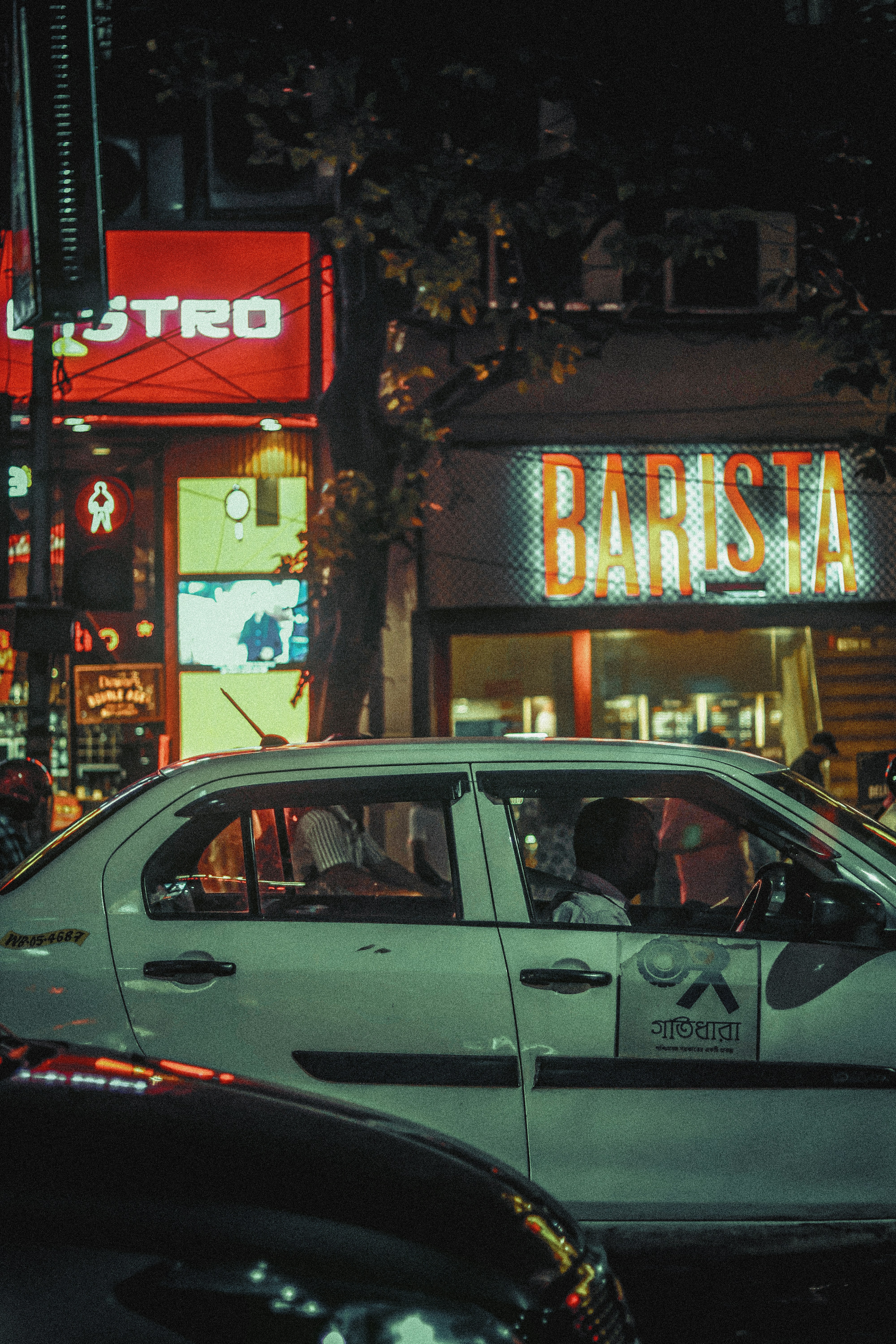 a taxi cab driving down a street at night