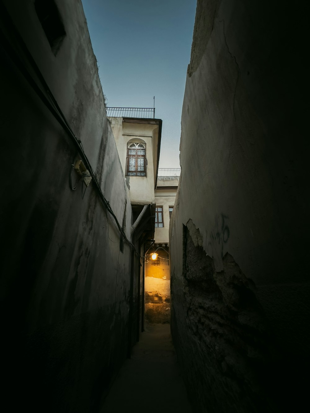 a narrow alley way with a building in the background