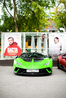 A bright green car with the Green Light Driving School logo parked in front of a Surrey street.