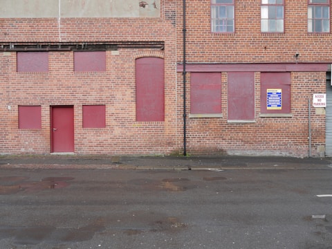 Photo of a secured empty building in Southampton on a rainy day, showing boarded windows and robust locks.