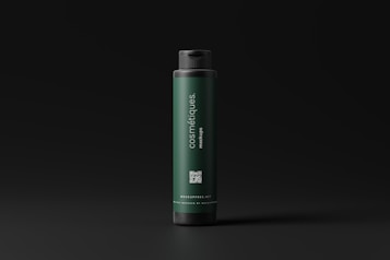 A dark green cylindrical bottle with a black cap stands against a dark background. The label on the bottle reads 'cosmétiques mockups' and includes a QR code as well as a website URL. The design is minimalistic and modern.