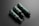Three dark green cylindrical bottles with black caps and dispensers are arranged diagonally against a dark gray background. The bottles have 'cosmétiques mockup' written on them in white text along with QR codes and other fine text details.