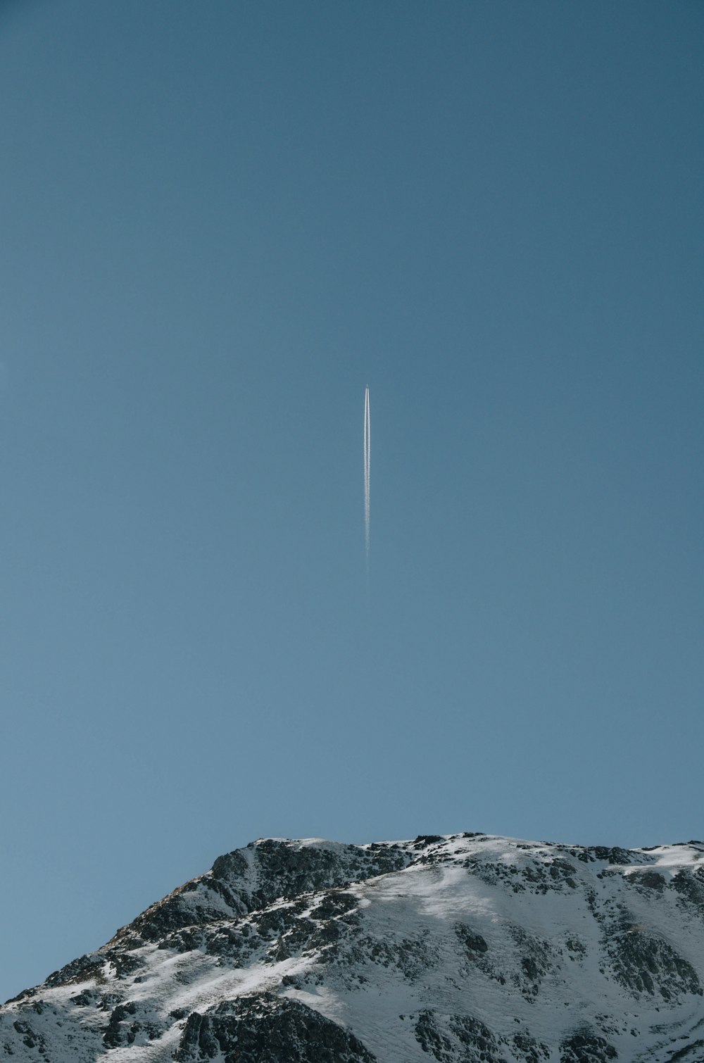 a jet flying over a snow covered mountain