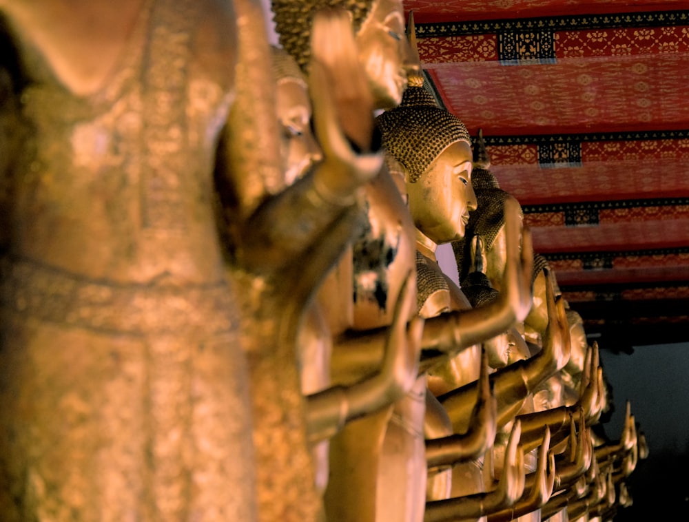 a row of golden buddha statues sitting next to each other