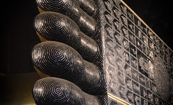 A close-up of intricate lippan art patterns on a textured surface.