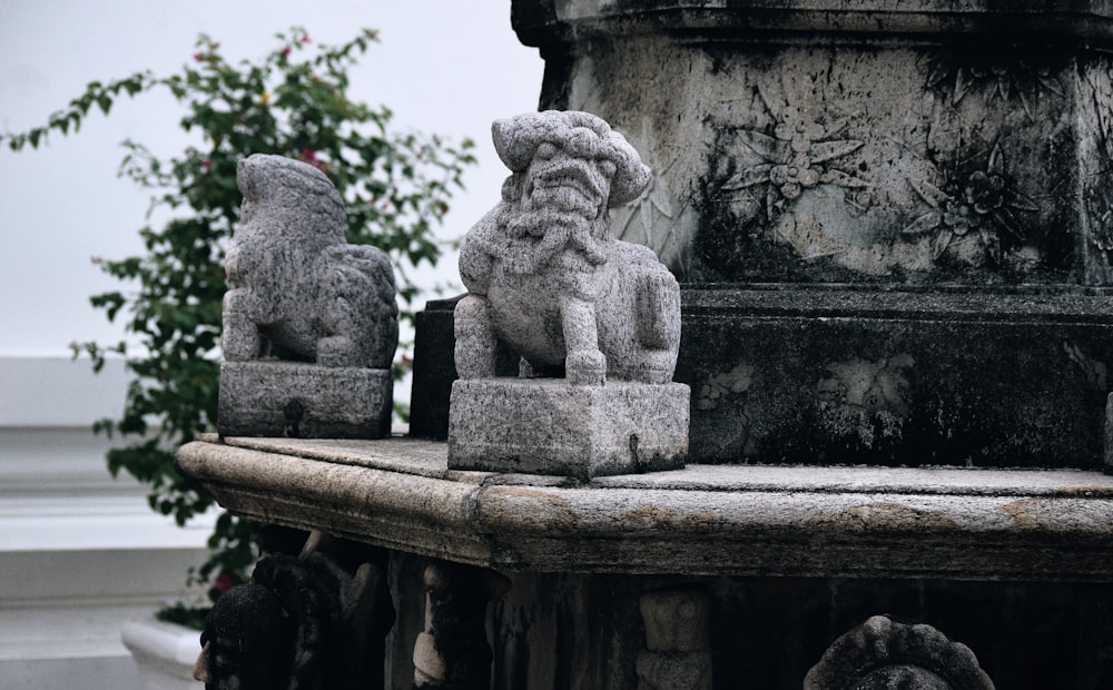 a statue of a lion and a dog on a pedestal