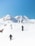 Several people are trekking across a snowy mountain landscape. The clear blue sky contrasts with the white snow-covered mountains in the background. The trekkers are wearing dark clothing and carrying poles, maneuvering through the snow.