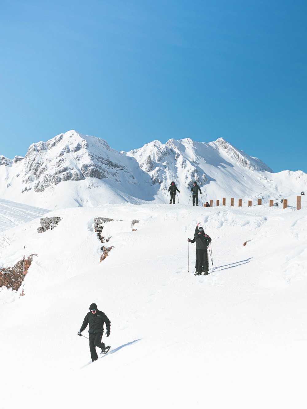 a group of people riding skis down a snow covered slope