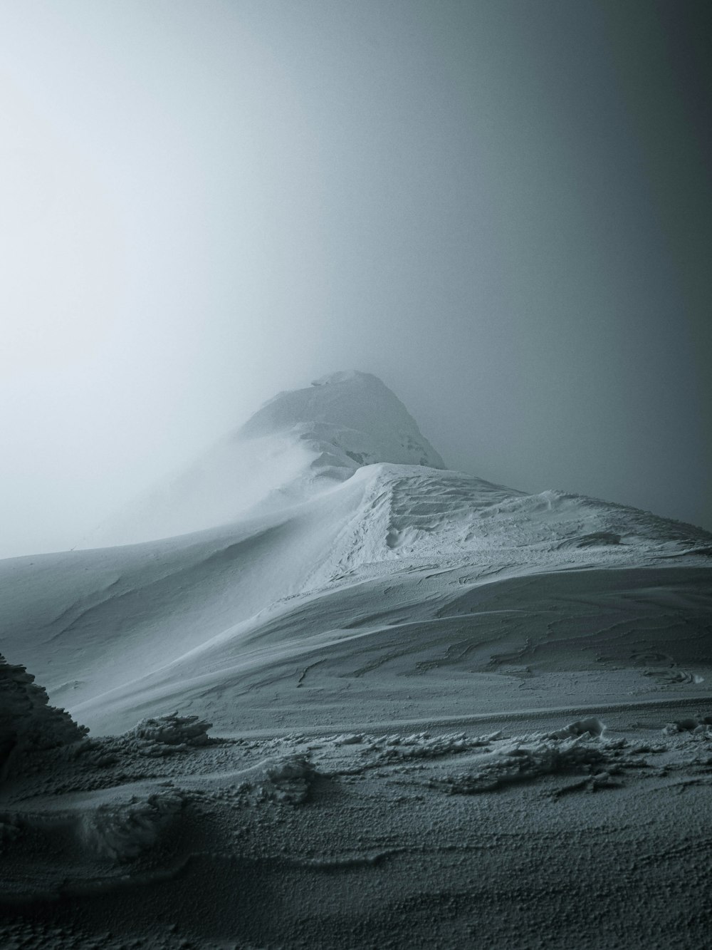 uma foto em preto e branco de uma montanha coberta de neve