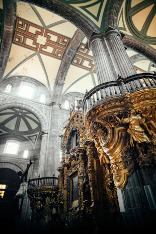 Interior of a restored Brazilian cathedral with ornate altars and historic frescoes illuminated by soft light.