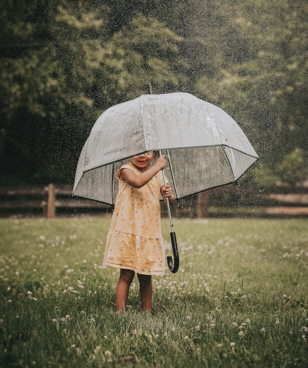 빗속에서 우산을 들고 있는 어린 소녀
