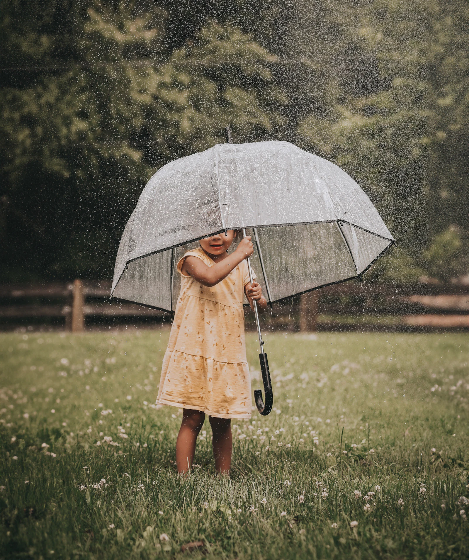A little girl holding an umbrella in the rain
