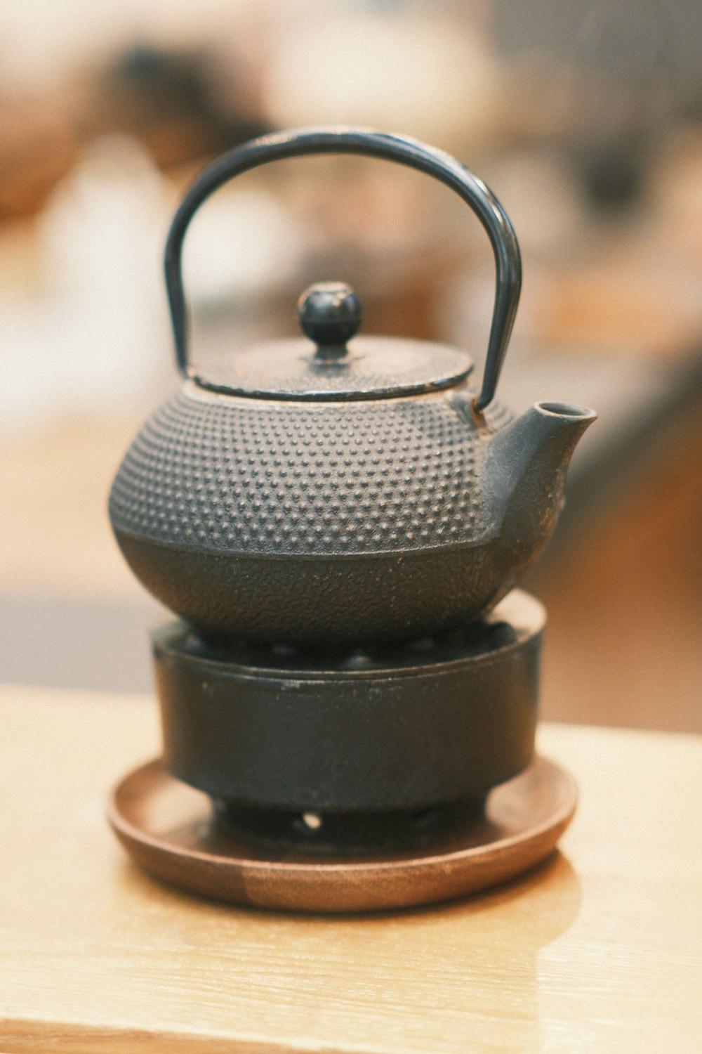 a black tea kettle sitting on top of a wooden table