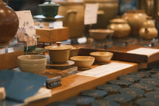 A collection of colorful pottery pieces displayed on a rustic wooden table.
