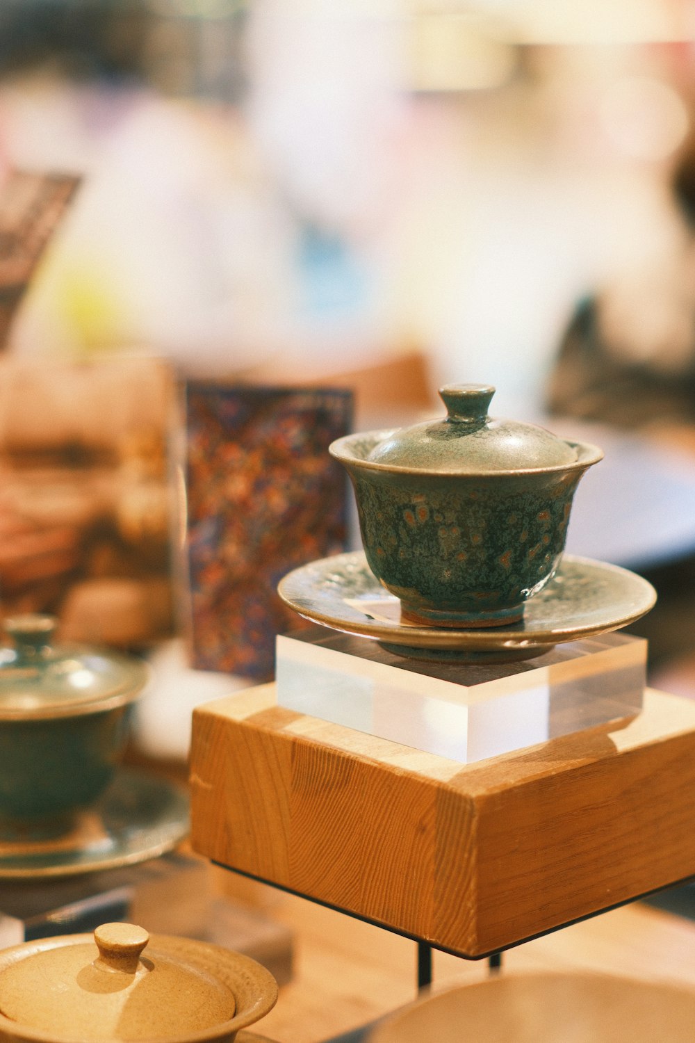 a wooden table topped with a tea pot and saucer