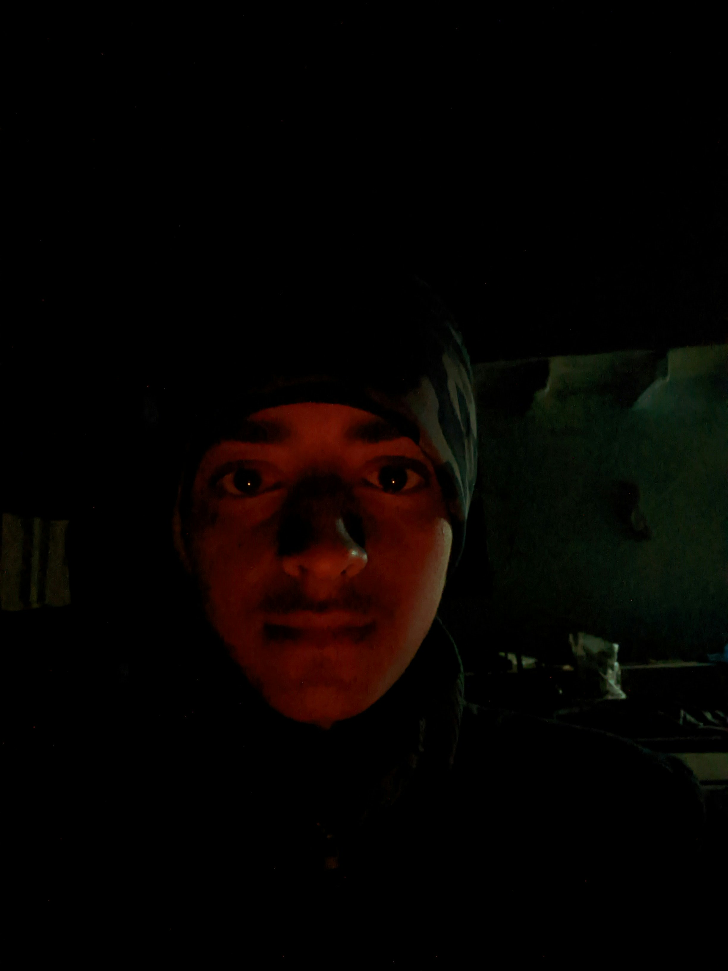 A man in a dark room with a red light on his face photo – Free Portrait ...