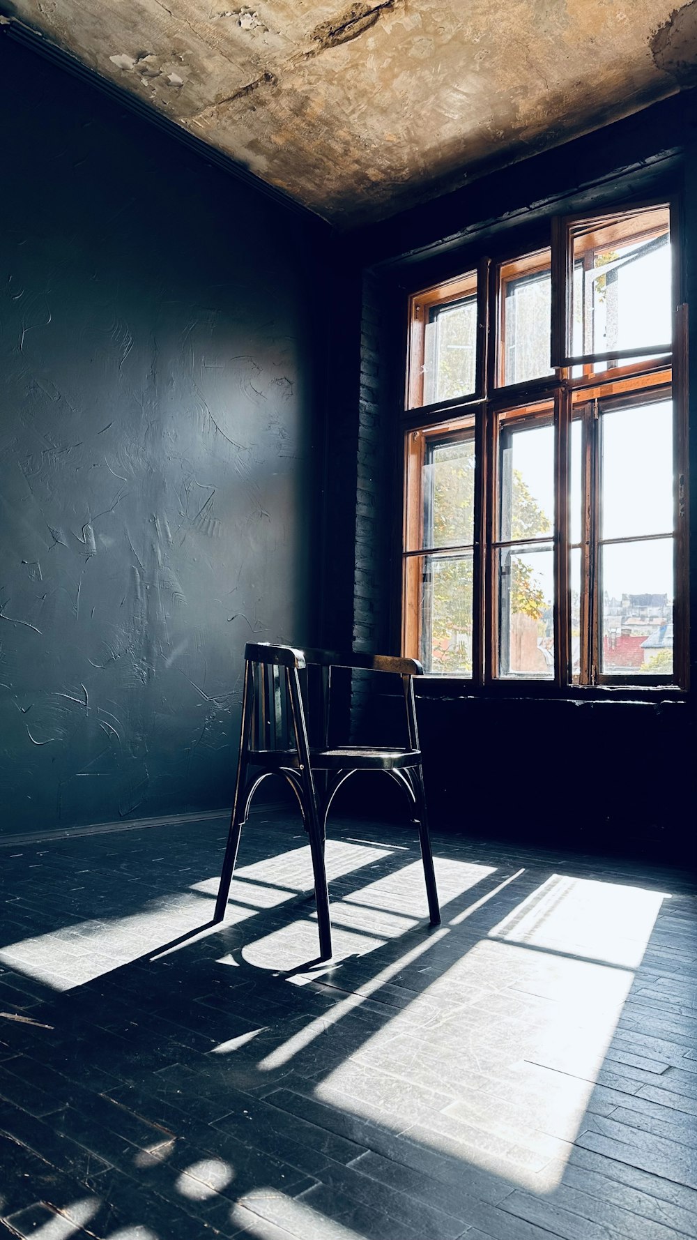 a chair sitting in front of a window in a dark room