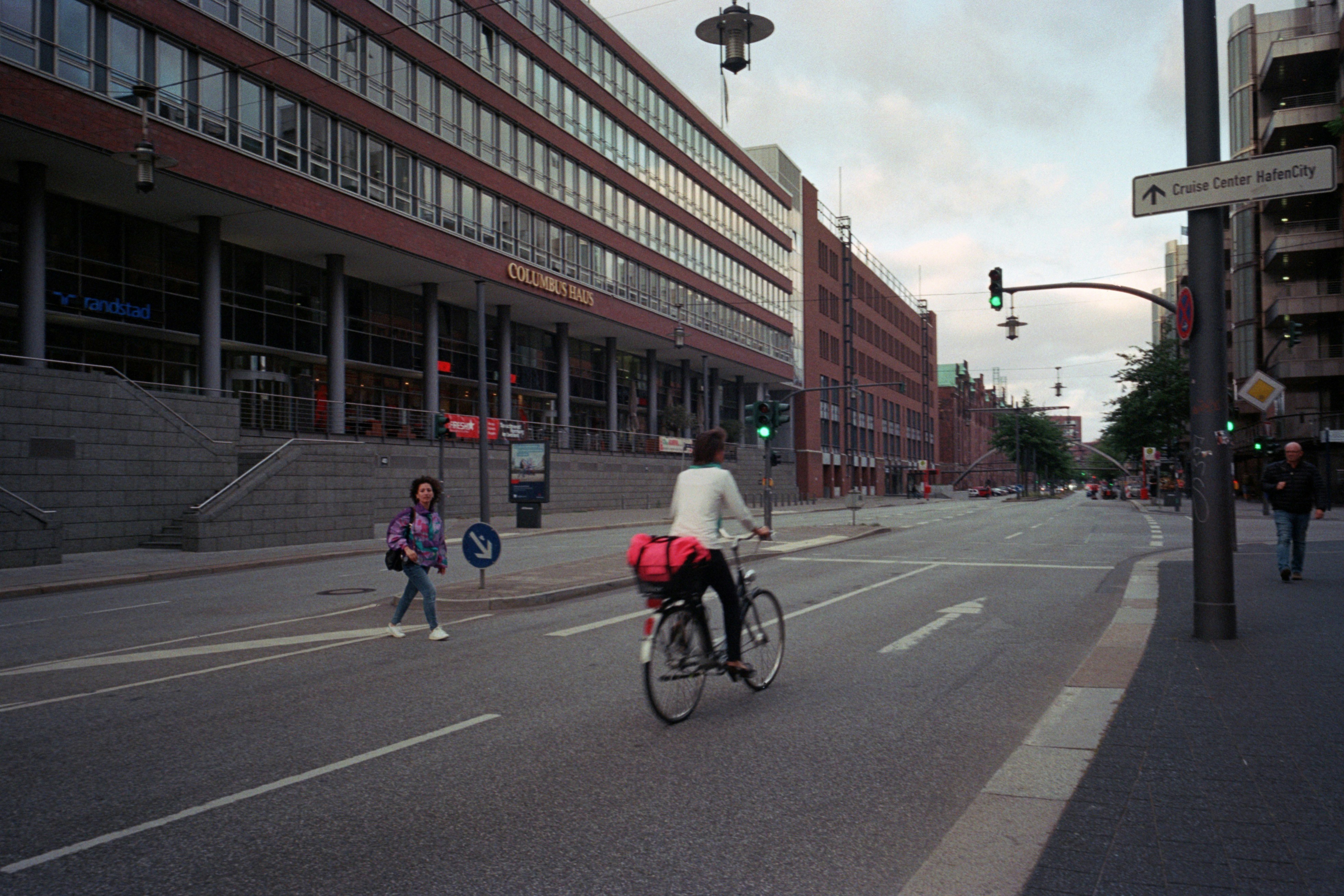 a man riding a bike down a street next to a tall building