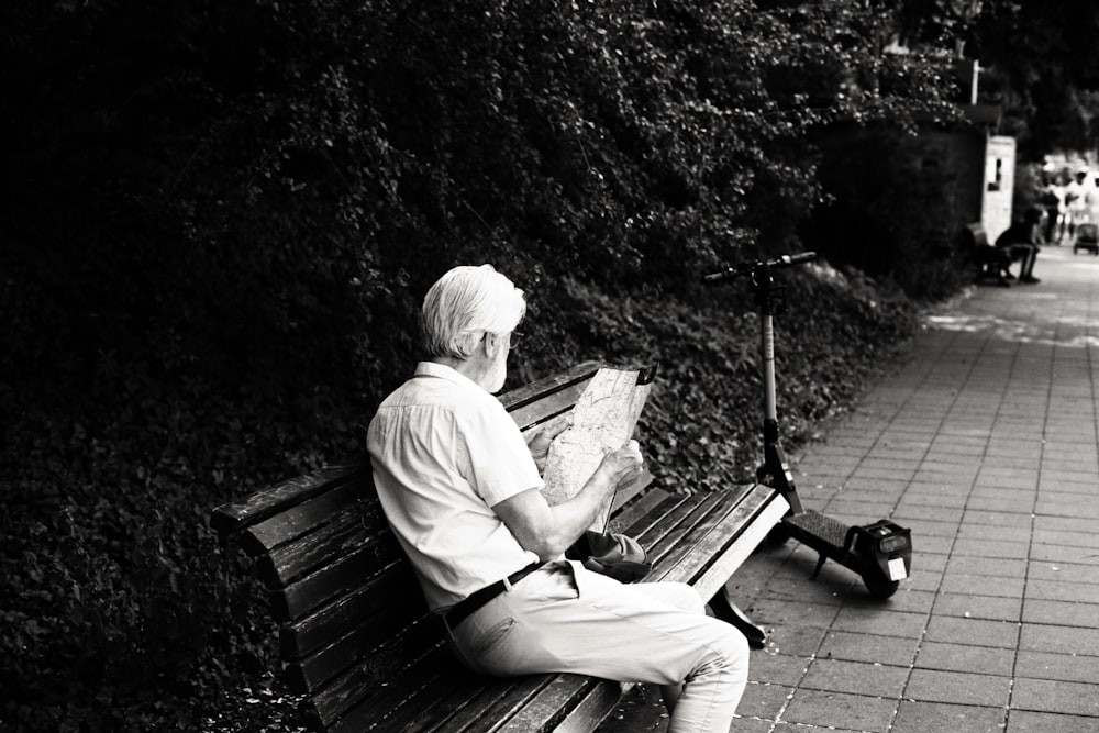 a person sitting on a bench reading a map