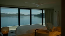 Modern bedroom featuring soft linens and tasteful decor overlooking the peaceful lake.