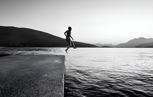 Amateur style black and white photo capturing the thrill and fun of the verticalvoid team mid-bungee jump with mountains behind.