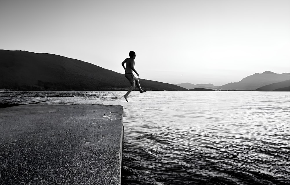 a person jumping off a dock into the water