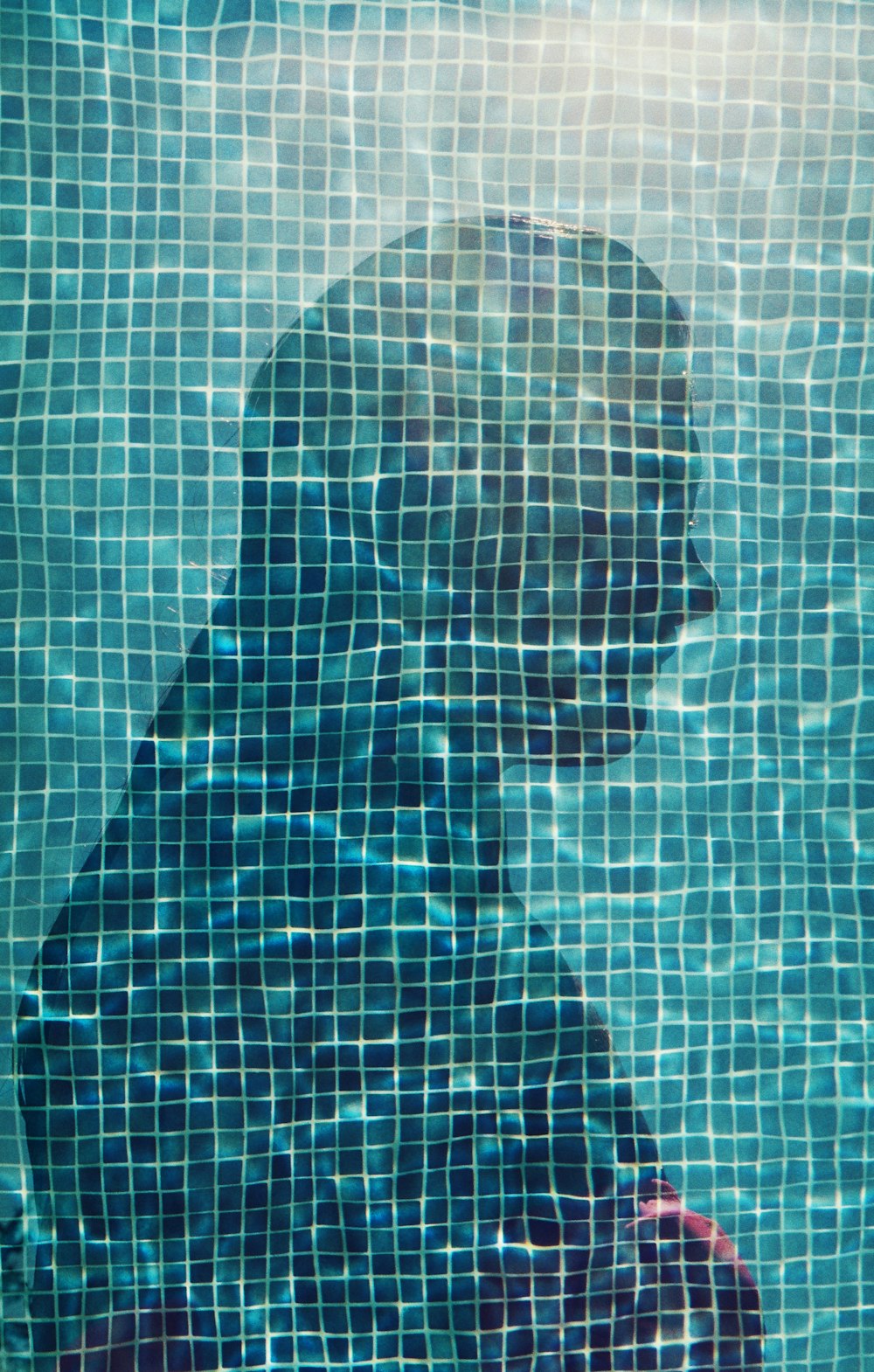a reflection of a man in a swimming pool
