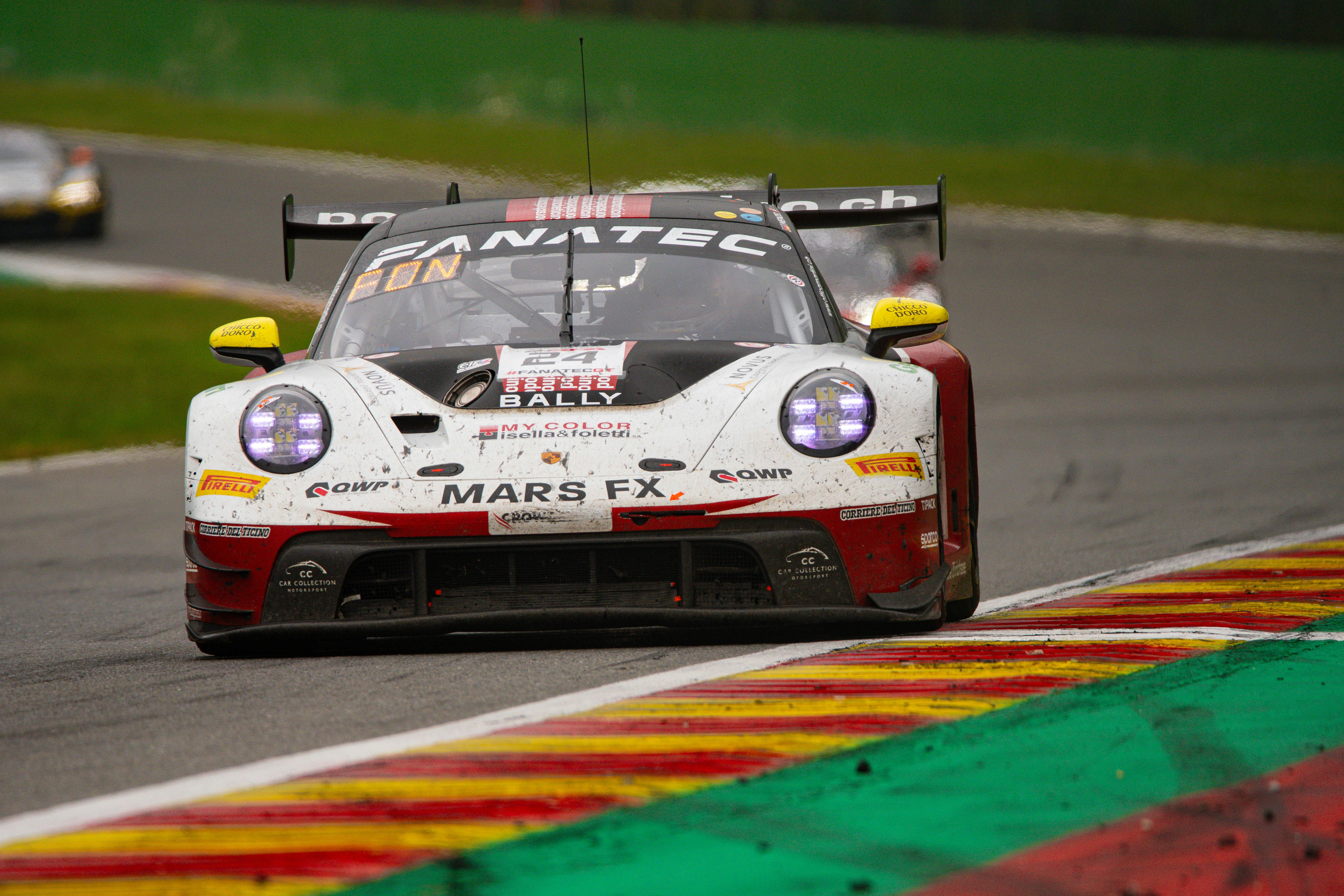 A white, with red and black Porsche 911 GT3 R under braking for the chicane at the end of the lap at Circuit de Spa-Francorchamps.