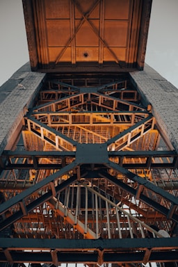 a very tall metal structure with a clock on it's side