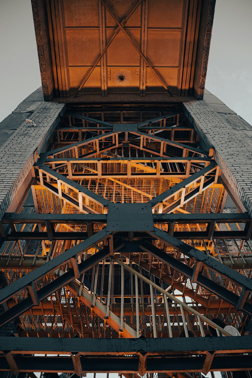 a very tall metal structure with a clock on it's side