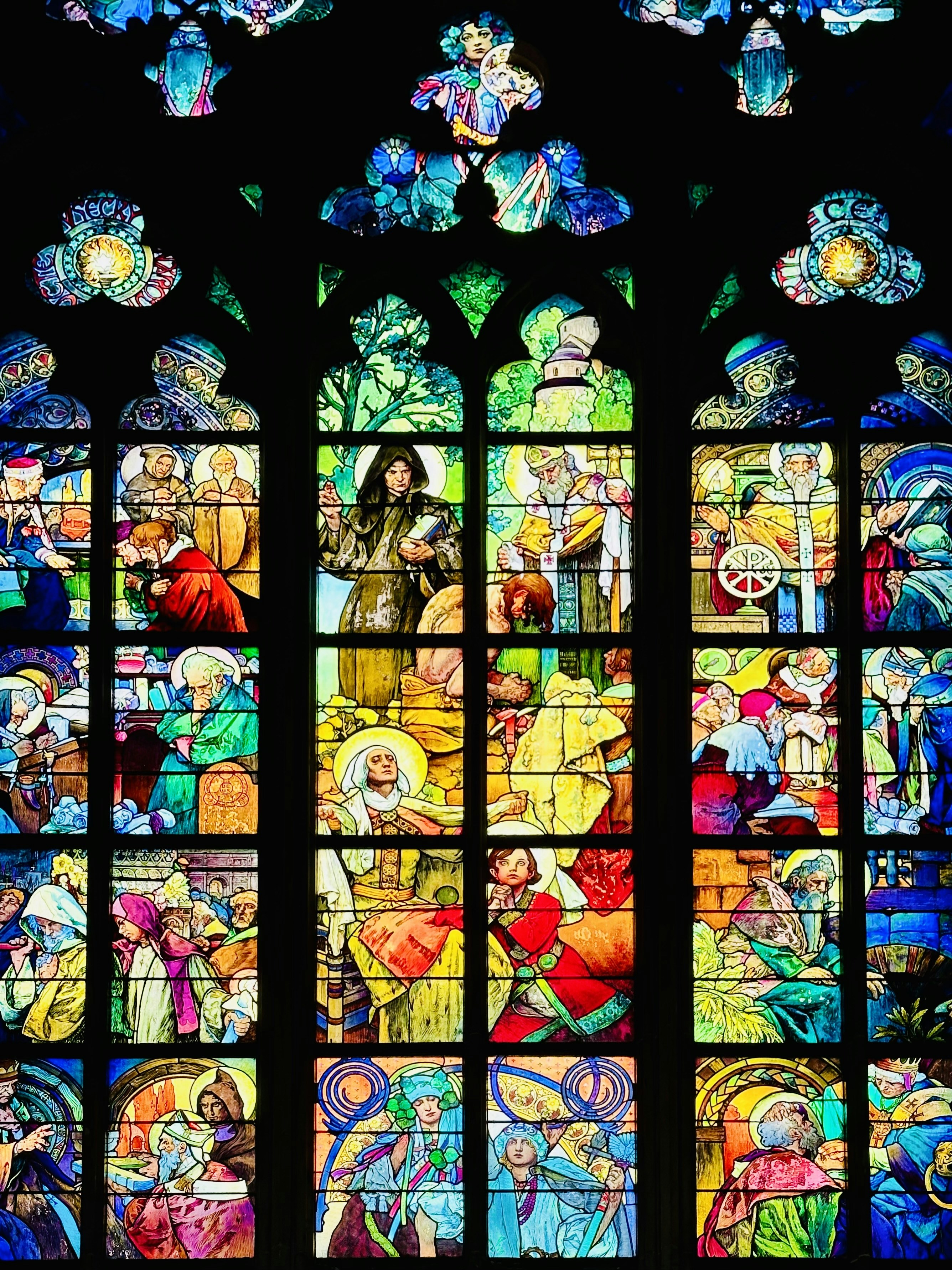 A large stained glass window with a lot of people on it photo Free