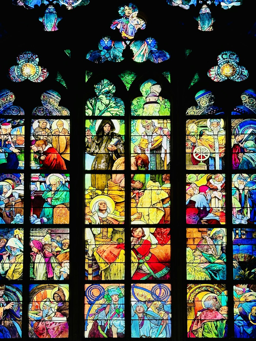 a large stained glass window with a lot of people on it