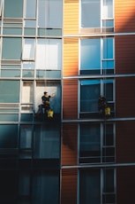 dos hombres en trabajo vertical limpiando ventanas