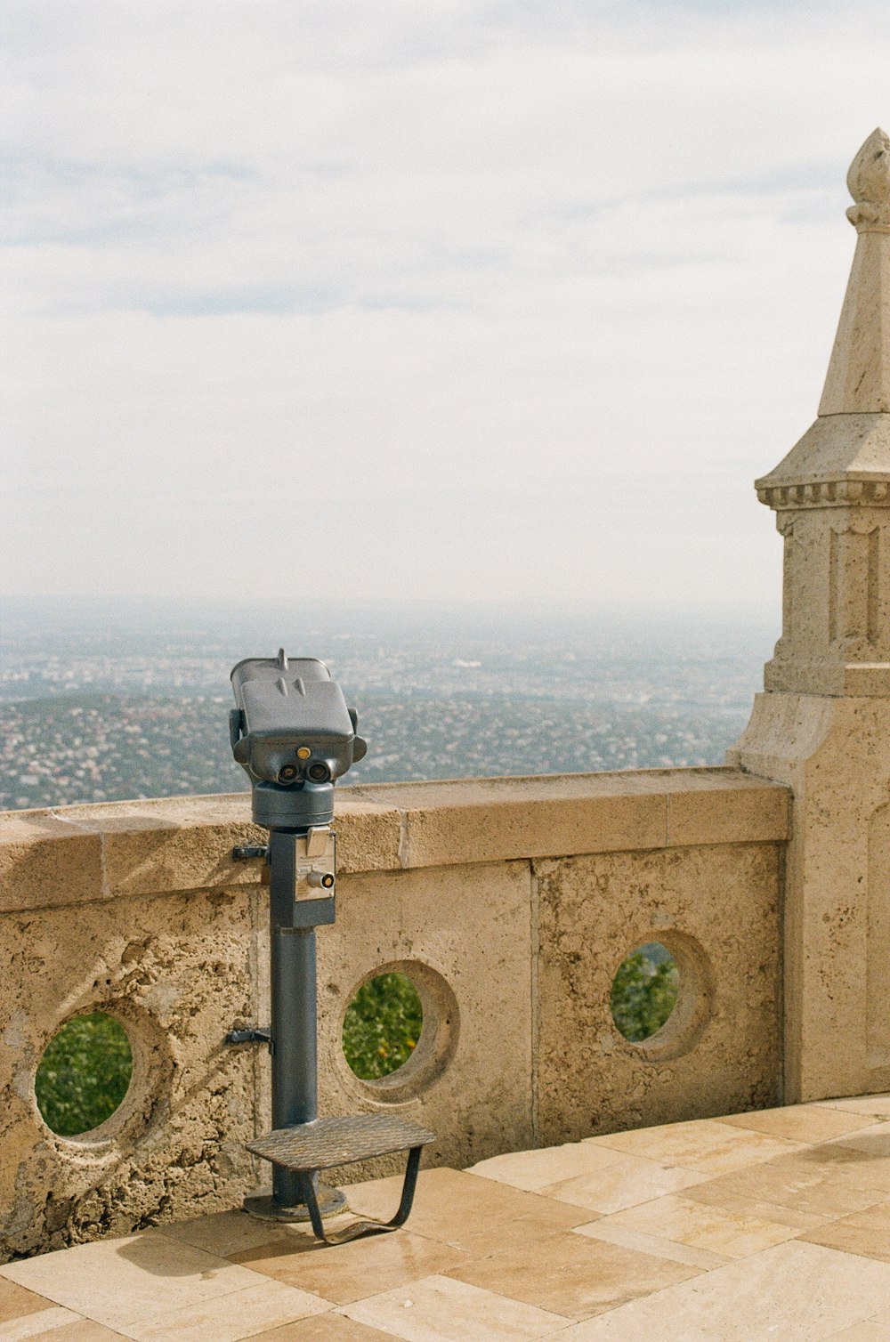 a bench on a stone wall with a view of a city