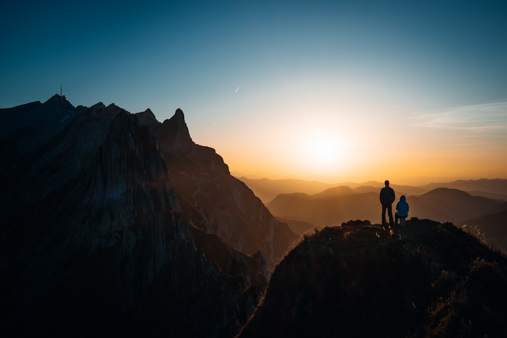 a couple of people standing on top of a mountain